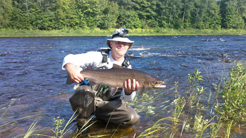 Chris Barnett with a fish that he caught on Saturday at the height of the raise we received on the LSW Miramichi